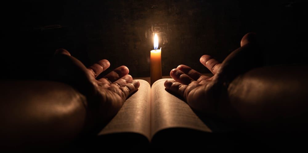 priere bible mains bougie